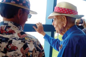 George Stallings, Jr. (right) and his stepson Jim Taylor, watch as the B-24 Liberator lands on the tarmac at Cecil Field Airport.