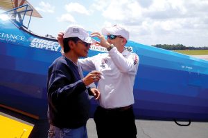 Becky Gill receives an autographed ballcap from Col. Bob Brodie.