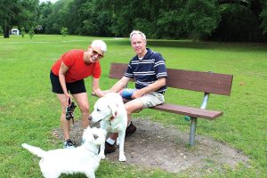 Park visitors Pam Sorenson and Piper and Earl Higginbotham and Jack in Alexandria Oaks Park near the train track.