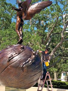Emmett Lodge applies a topcoat of wax to the newly cleaned statue, Spiritualized Life.