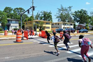 While Pat Bridgeman holds up traffic in the northbound lanes of Hendricks, children still run across the southbound lanes making for a potentially dangerous situation.