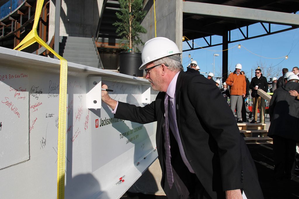 Jacksonville City Council President Aaron Bowman signs the final beam for the Regional Transportation Center prior to its placement on the building.