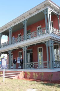 Gordon Steadman, Danis Construction vice president of business development, chats with North Florida Land Trust President Jim McCarthy, on the porch of the renovated Brewster Hospital, now headquarters for the nonprofit land conservation organization.