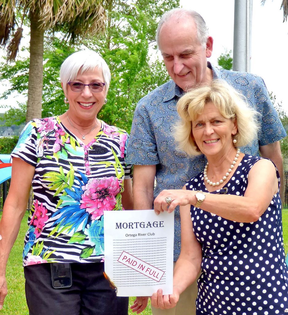 Elaine Atchison and Larry Alford with Lajana Hill holding the paid mortgage for the Ortega River Club.