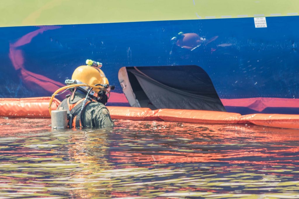 Navy contractor partner divers enter the water May 6 to provide a thorough underwater description of the condition of the Boeing 737 aircraft lying in the St. Johns River at Naval Air Station Jacksonville. The divers will help the onsite team to determine the safest way to remove the aircraft from the water. (U.S. Navy Photo by Jeffrey Hamlin/Released)