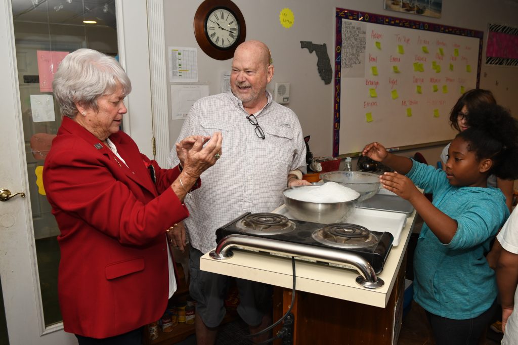 Anne Nimnicht shows Pastor Clint Wilder’s students how dry ice clouds disappeared when she clapped her hands.