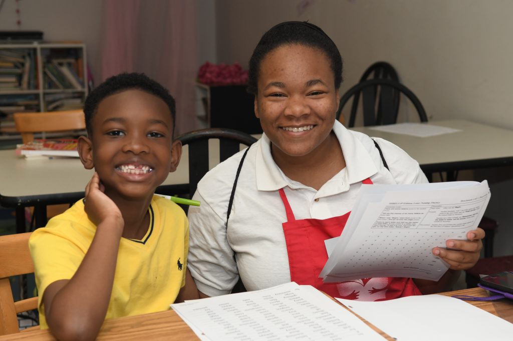 A Teen Tutor helps a summer camper improve his reading skills.