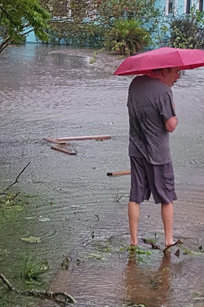 David Gum wades through water near his home.