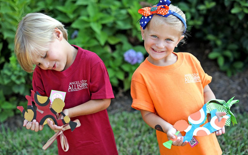 Two little angels hold painted angels from Angels for Allison