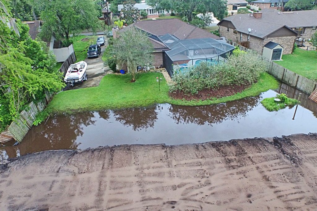 Flood water stands in the backyards of David and Lynne Robison (left) and Kevin Conner (right).