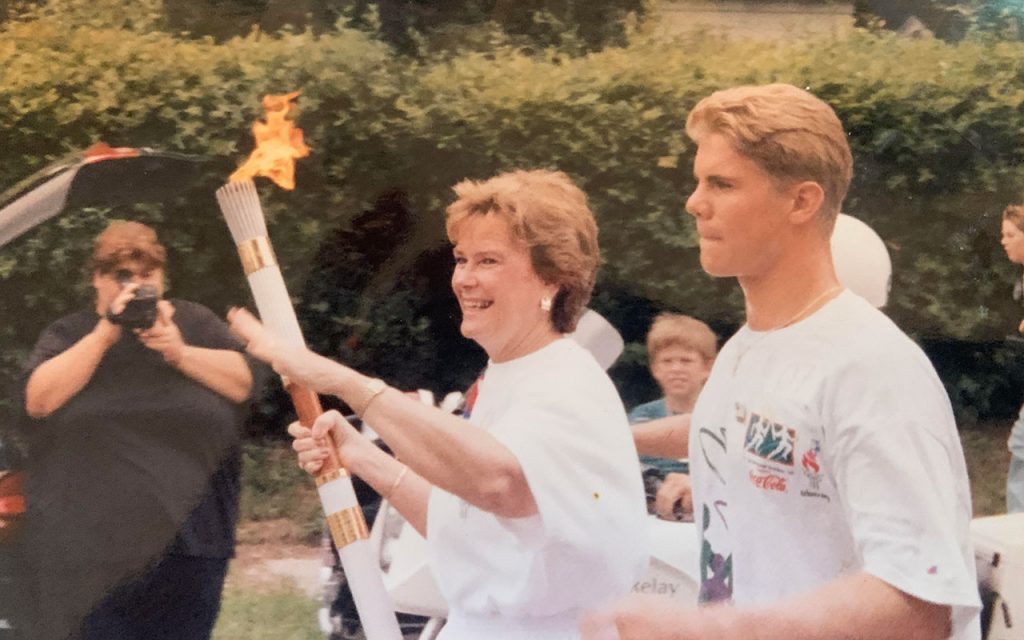 Sissy carrying Olympic torch with escort Scott Blinkhorn