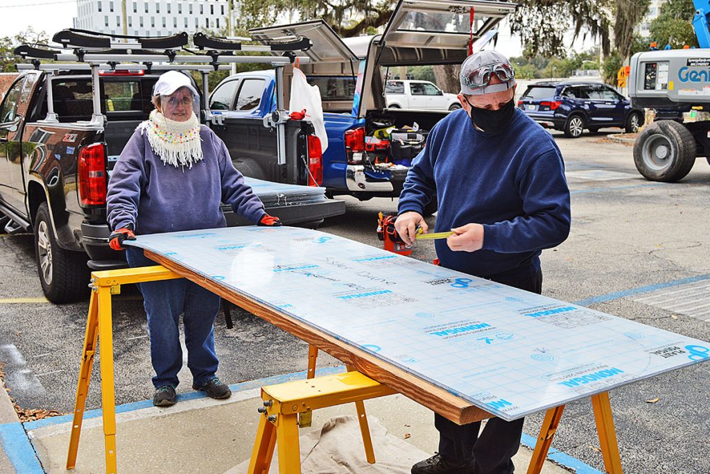 Sister Diane Couture works with Jeffrey Moore in cutting Lexan to fit over the stained-glass windows at Riverside Presbyterian Church
