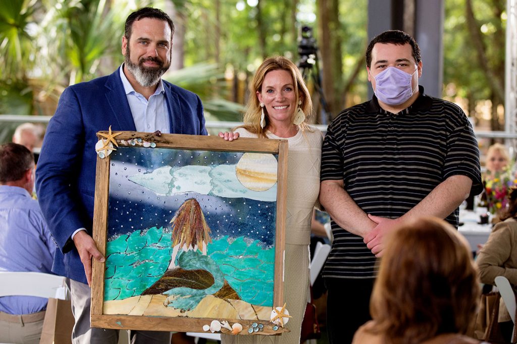 Event Chairs Maren and Paul Bertozzi being presented with custom stained glass by Art With Soul Artist, Braxton Beattie.