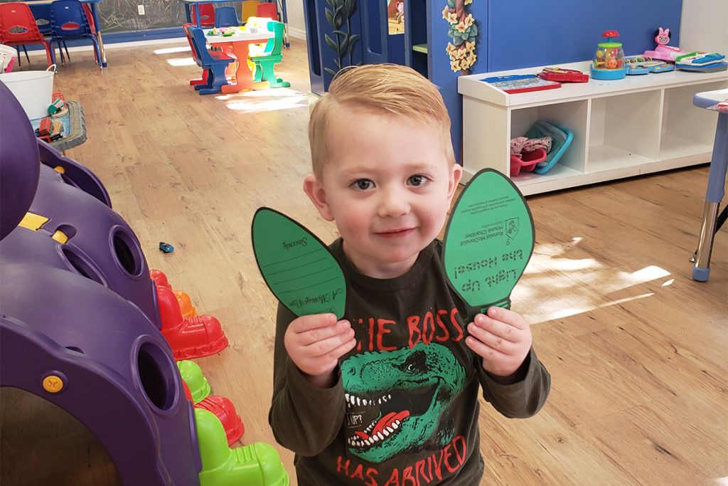 A young guest shows off a holiday paper light icon.