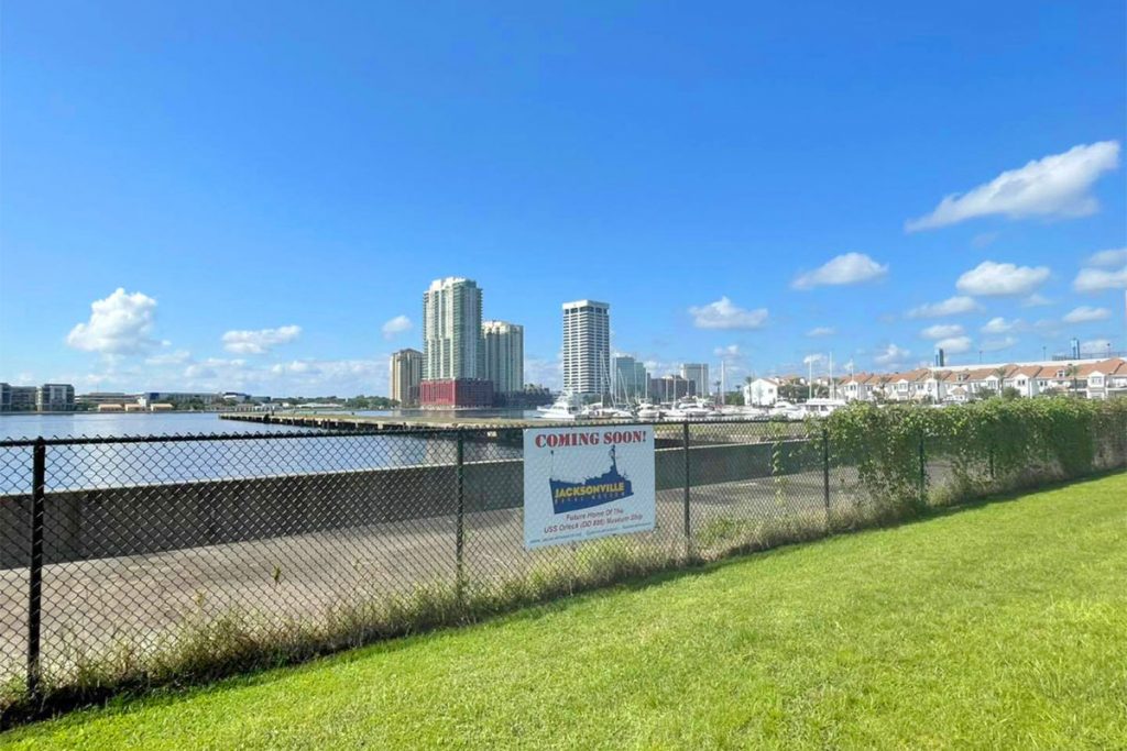 Signs on a fence bordering Jacksonville's waterfront announce the highly anticipated arrival with a 'Coming Soon' banner.