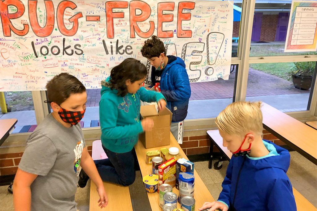 Students in Stockton Elementary School’s Anchored4Life program pack boxes food to give to The Salvation Army for families in need.