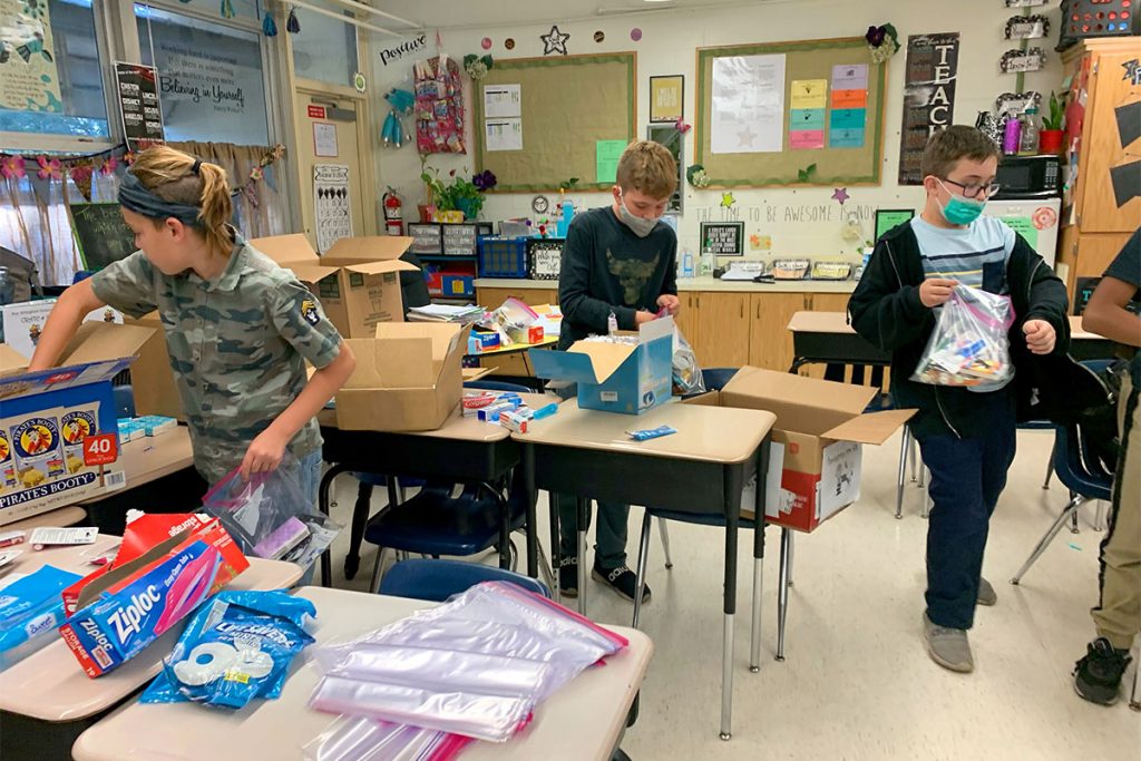 Students sort more donated food. They collected three barrels of food – almost 1,500 items – to donate.