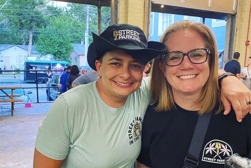 Stacey Steiner in "STREET PARKING" tshirt, with woman in "STREET PARKING" hat