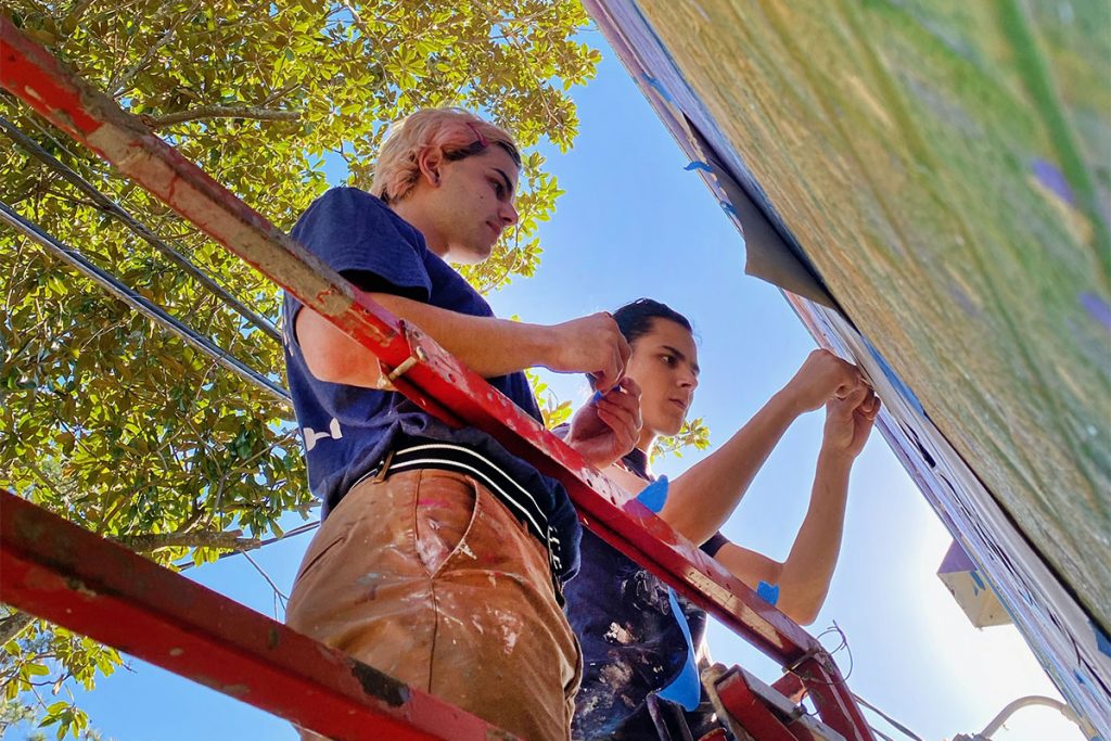 Artists Corey Kreisel and Ramses Allen finalizing “Generations”, Avondale’s first large-scale mural.