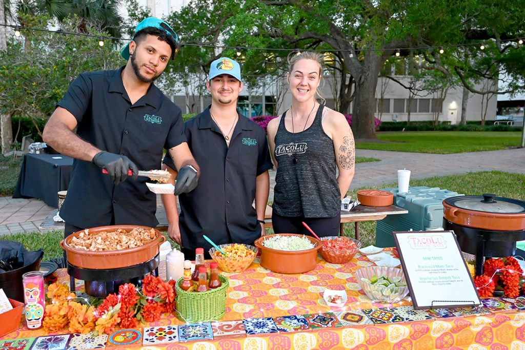 TacoLu workers at table of food smiling
