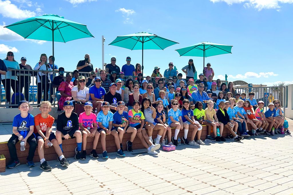 Group shot of kids sitting under umbrellas