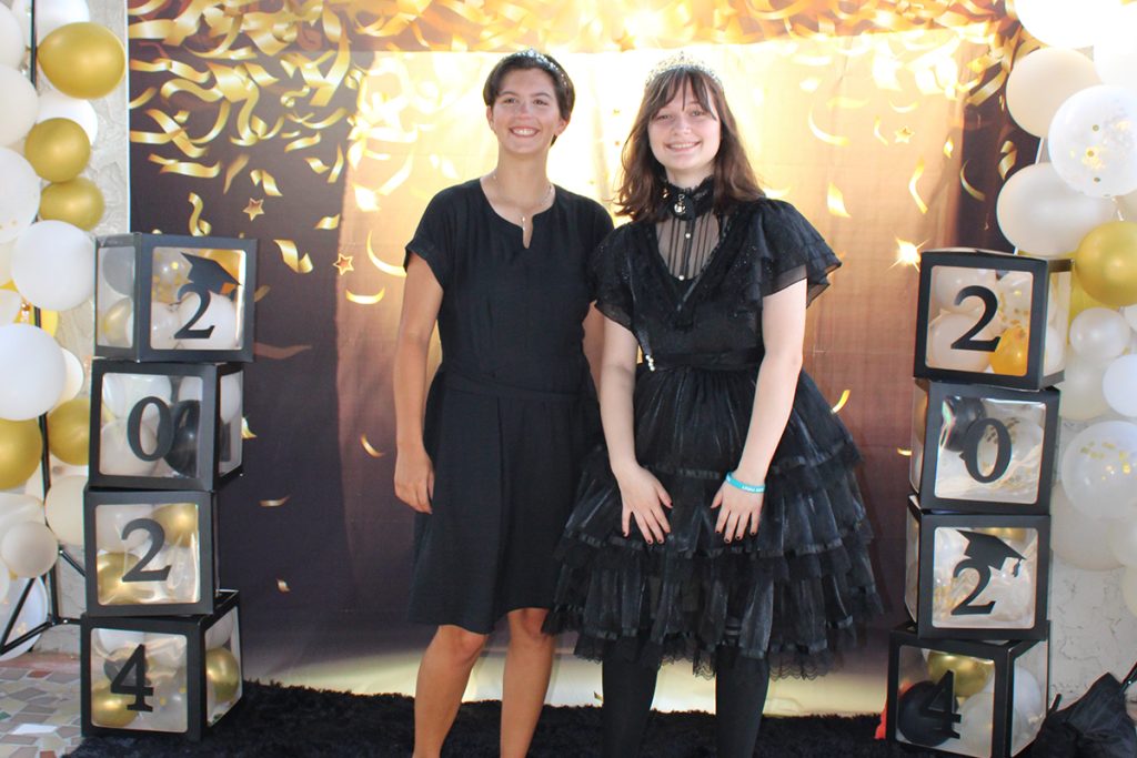 two smiling students with confetti background