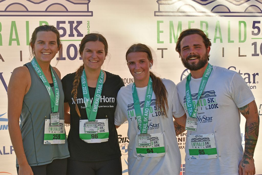 smiling people with Emerald Trail 5K gear on