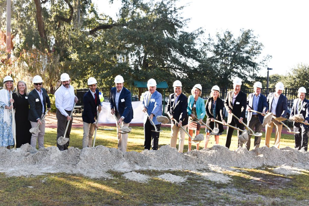 men and women with shovels shoveling dirt
