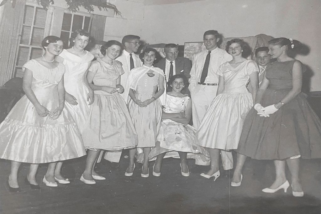 Linda Burbridge (Knight), Bonnie Patterson, Beth Walker (Slifer), Brian Rosborough, Agnes Ellis (Danciger), Bob (Robby) Breen, Meta Bond (Magevney), Bill Gibbs, Dorothy Coulter (Adams), Gress LeMaistre, and Robin Rhodes (Browning) pose for a group photo at a 1950s-era Junior Assembly dance at Friday Musicale.
