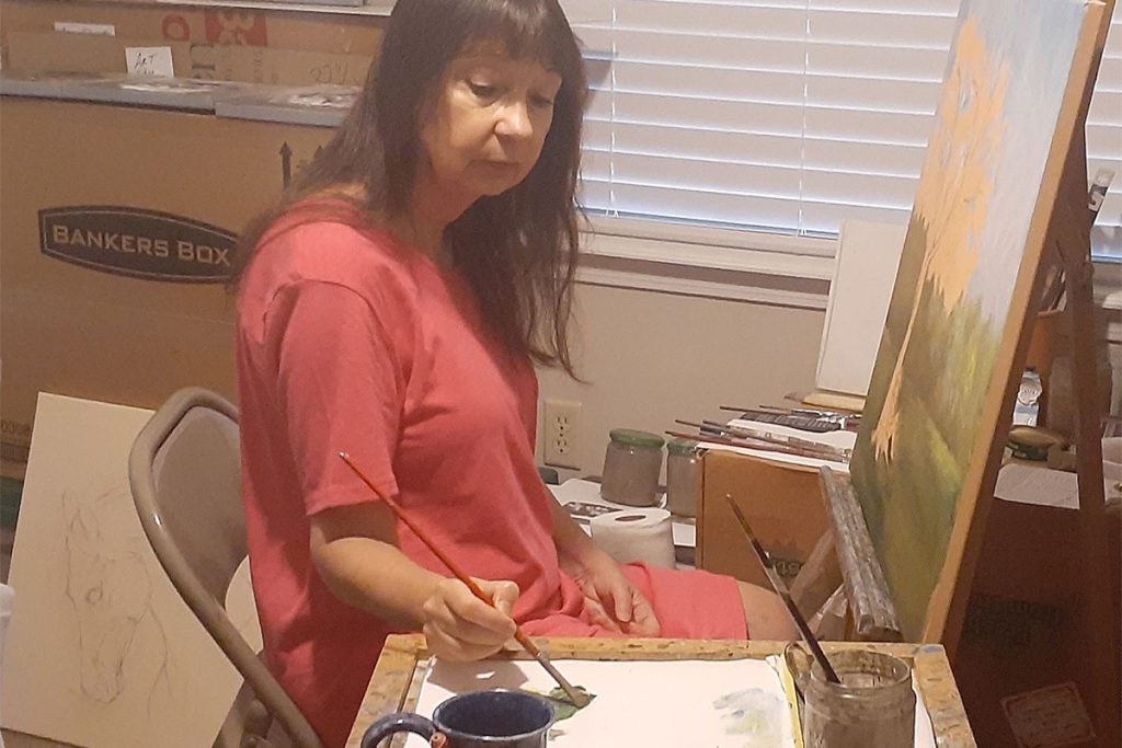 Laurel sitting in a chair and painting