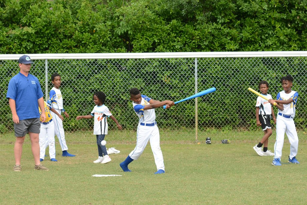 A baseball player from FSCJ provided hitting coaching to youth participants.