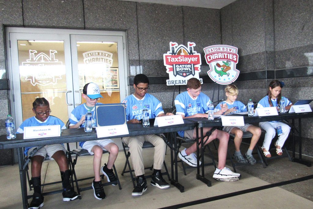 Dream Team members sign their certificates.