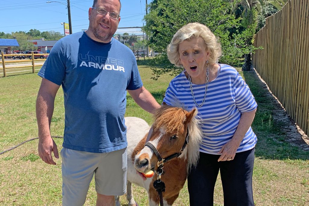 Suzie Loving with veteran Patrick L. feeding apples to mini pony Cupid.