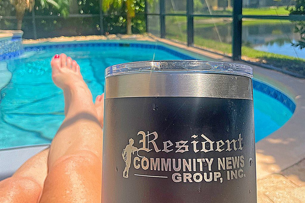 poolside photo with Resident Community News mug
